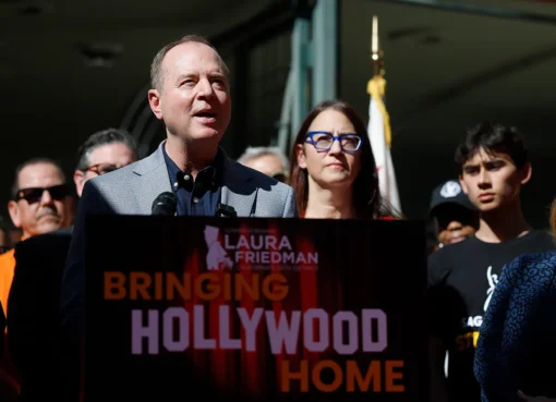 A group of people, including Sen. Adam Schiff, speaking at a podium with microphones, suggesting a political campaign or announcement related to film incentives.