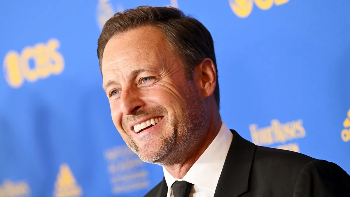 Chris Harrison speaking at a microphone.
