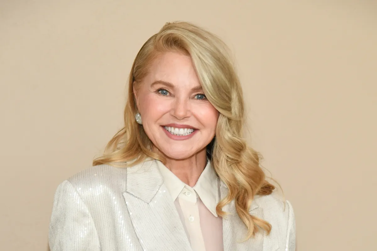 Christie Brinkley smiling and holding film reels, suggesting a look into her past.