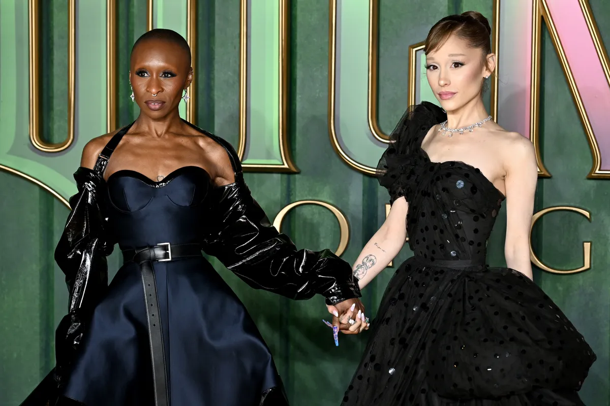 Cynthia Erivo and Ariana Grande smiling together on a red carpet.