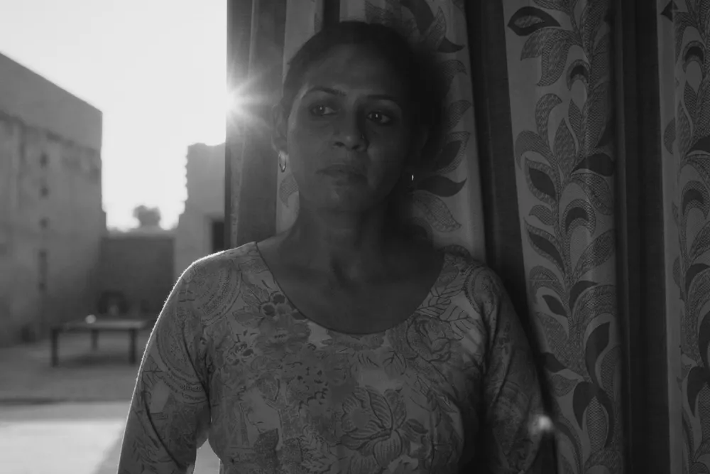 A film still showing a tense, dark scene from 'Birds in the Dark' with characters in dimly lit environment.