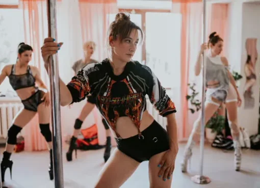 A woman mid-pose on a pole, demonstrating strength and grace.