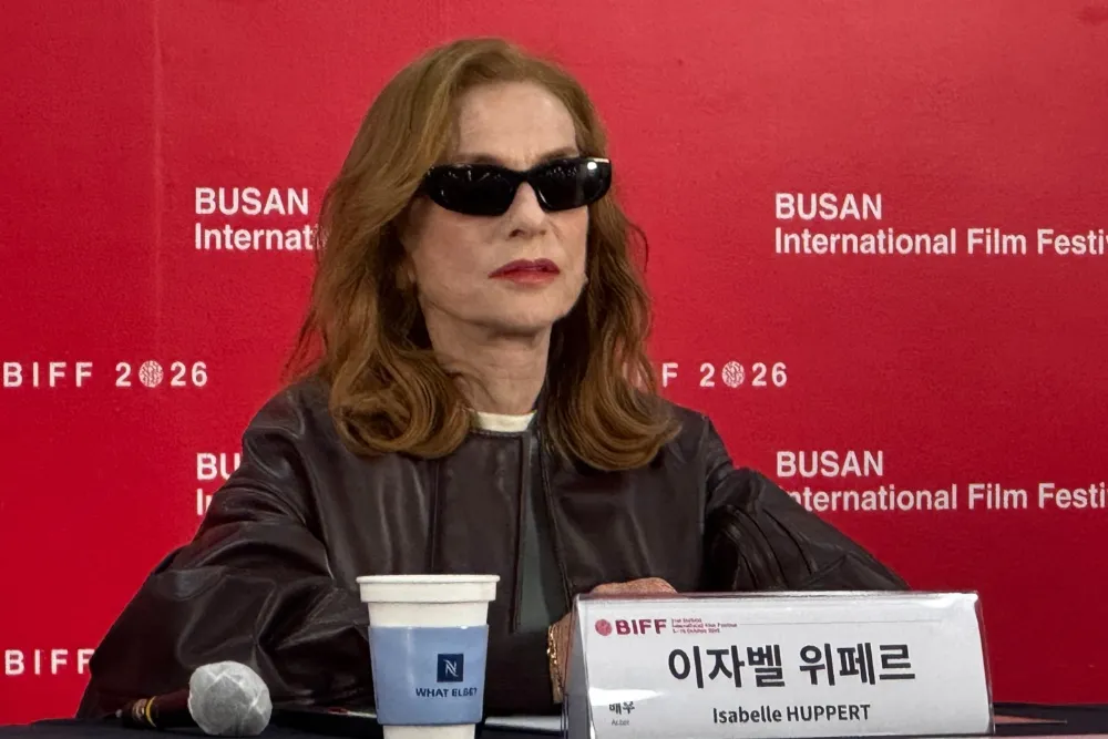 Isabelle Huppert, a French actress, smiling at a press conference.