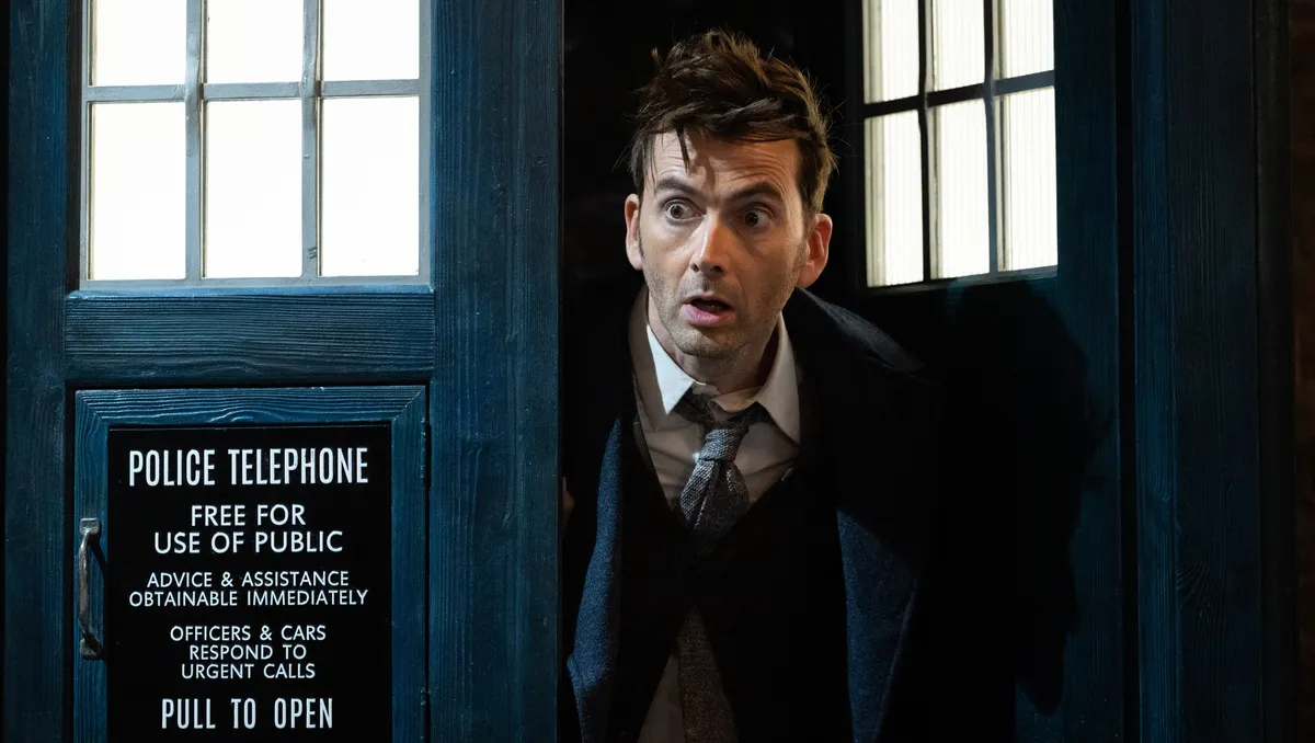 The iconic blue TARDIS from Doctor Who landing in a scenic, misty Scottish landscape.