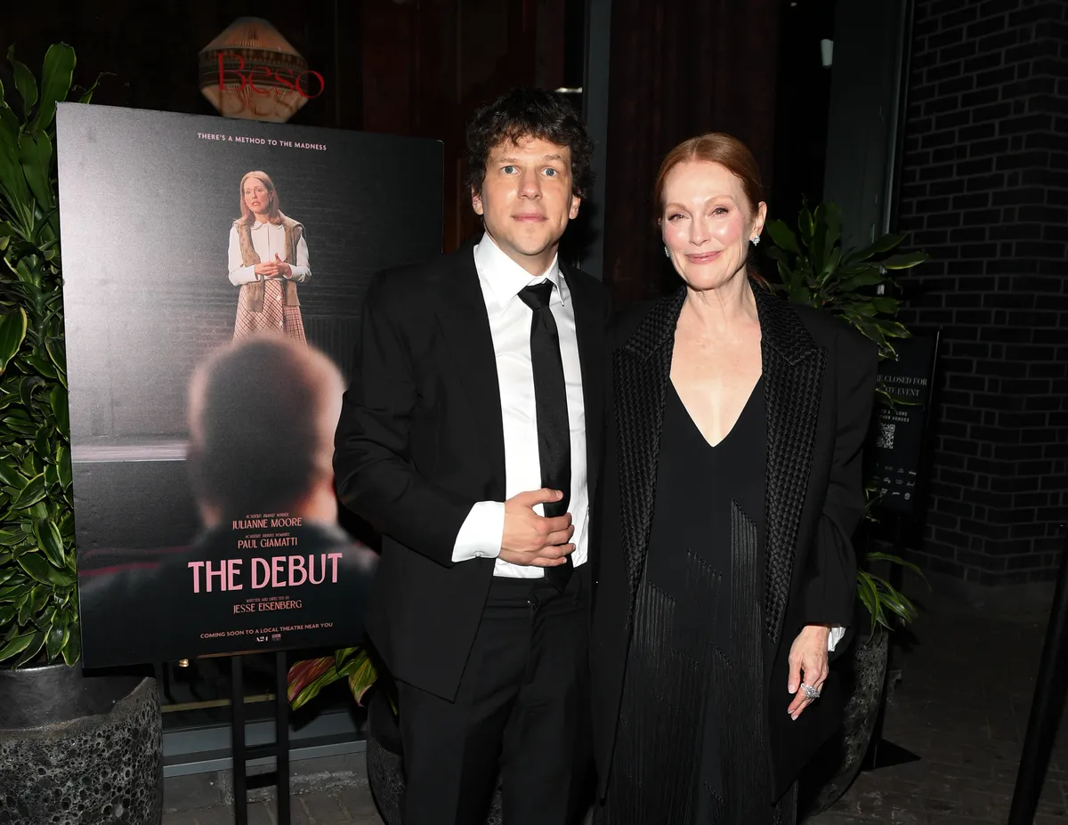 Jesse Eisenberg and Julianne Moore smiling together at a film premiere event.