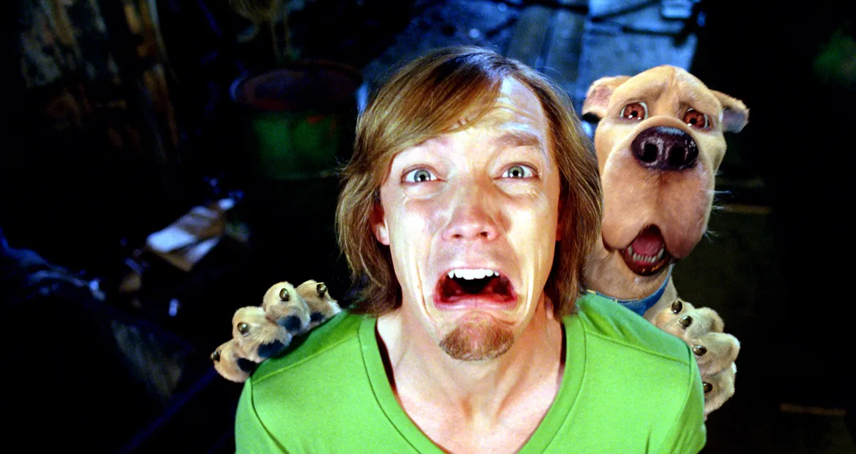 Matthew Lillard dressed as Shaggy Rogers from the Scooby-Doo live-action movies, looking surprised and a little worried.