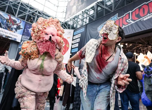 Cosplayers posing at New York Comic Con, with colorful costumes and excited fans in the background.