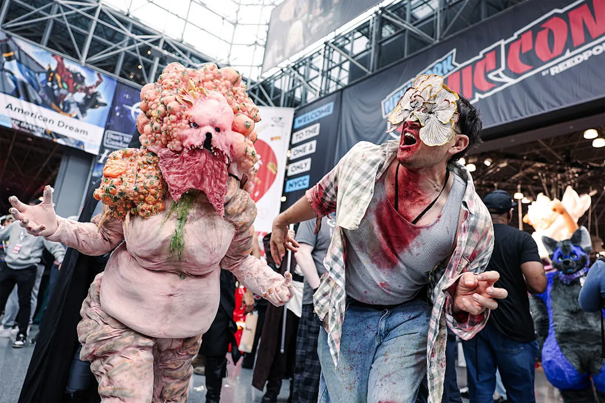 Cosplayers posing at New York Comic Con, with colorful costumes and excited fans in the background.