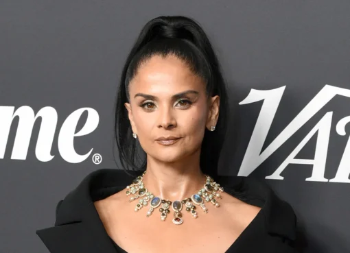 A smiling Bela Bajaria, a woman with dark hair and a bright top, speaking at an event.