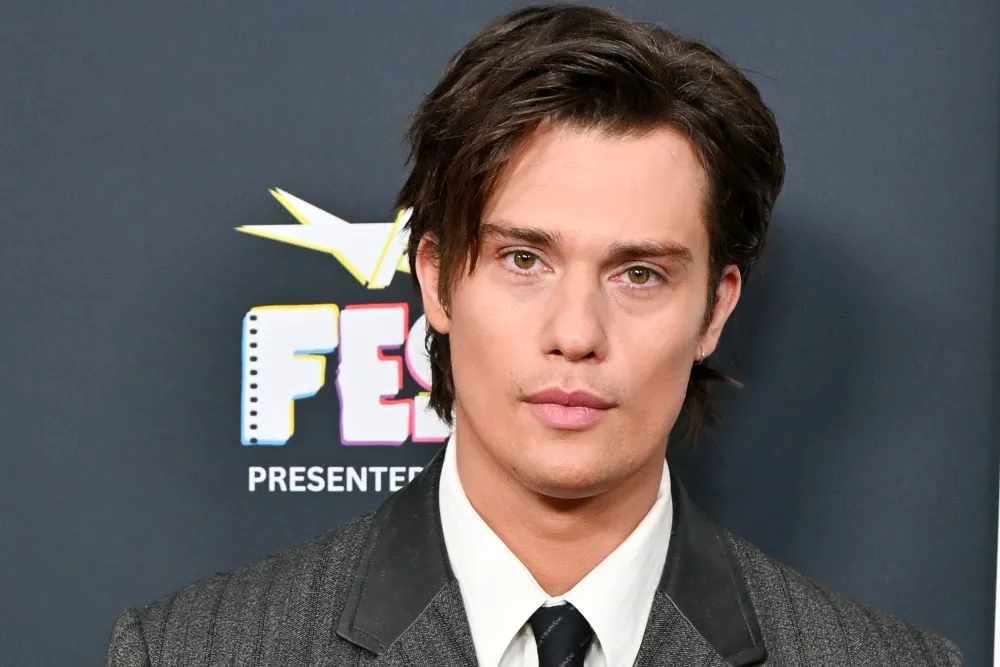 Nicholas Galitzine smiling at a premiere, looking dapper.