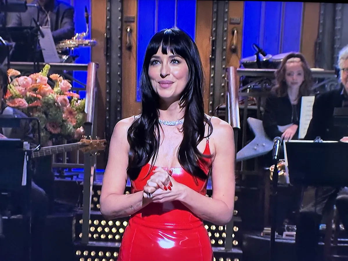 Taylor Swift and Dakota Johnson laughing on stage during SNL.