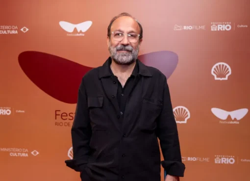 Asghar Farhadi speaking at a film festival, looking thoughtful and engaged.