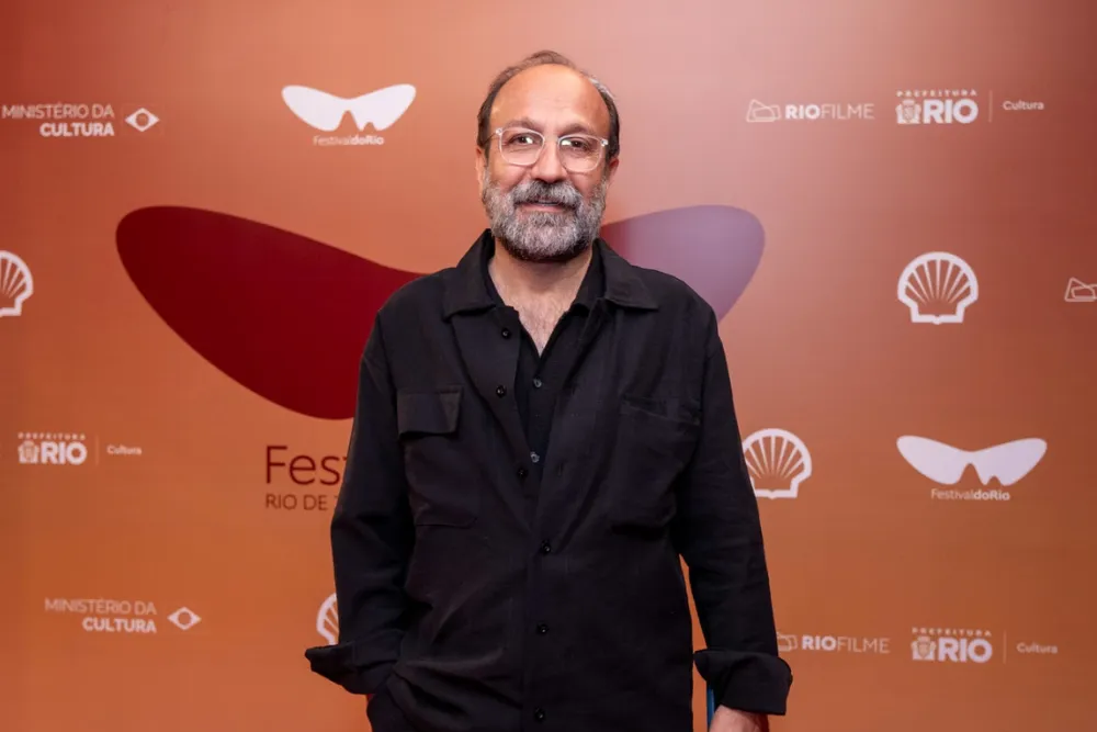 Asghar Farhadi speaking at a film festival, looking thoughtful and engaged.