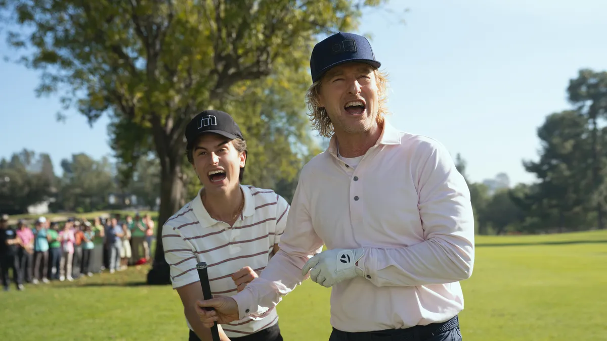 Owen Wilson as Pryce Cahill in 'Stick Season', standing on a sunny golf course with a club.