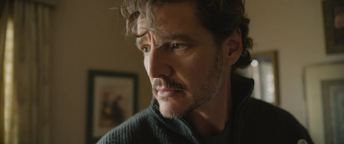 Pedro Pascal with a focused expression, holding a cello.