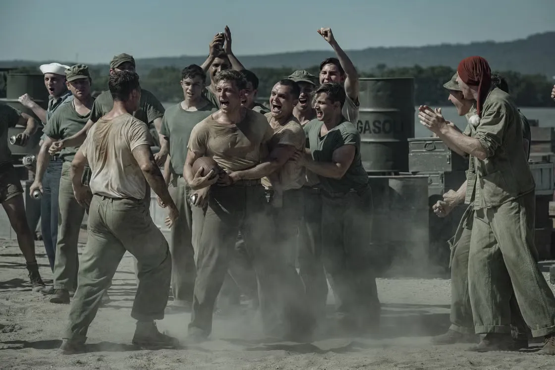 Dramatic scene from a World War II combat movie, showing soldiers on a battlefield.