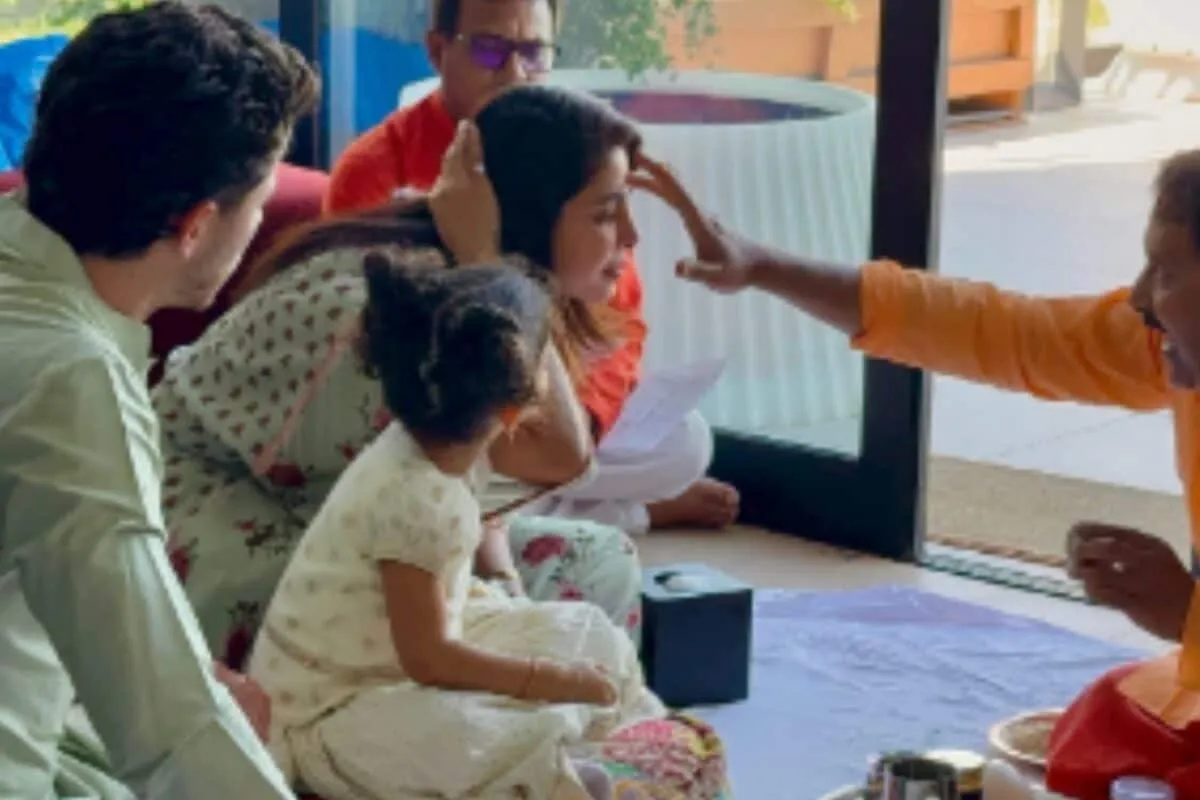 Priyanka Chopra and Nick Jonas sitting with daughter Malti during a traditional Kanya Pujan ceremony.
