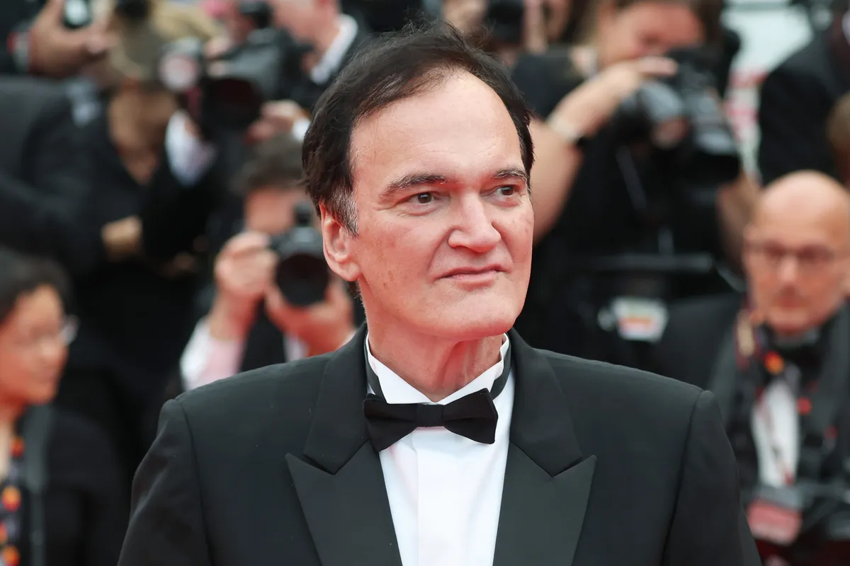 Quentin Tarantino smiling and looking thoughtful during an interview.
