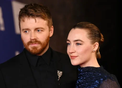 Saoirse Ronan smiling warmly, with a subtle backdrop that suggests her husband, Jack Lowden.
