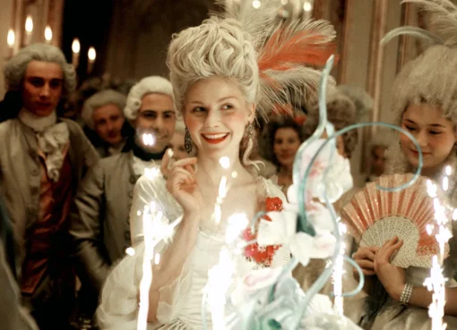 Still from Sofia Coppola's Marie Antoinette showing Kirsten Dunst looking regal amidst pastel cakes.