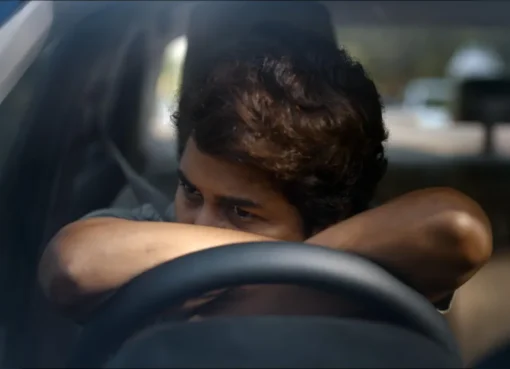 A dark, moody image of a taxi driving through the streets of Mumbai at night, hinting at a thriller.