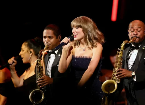Taylor Swift performing on stage at a formal event.