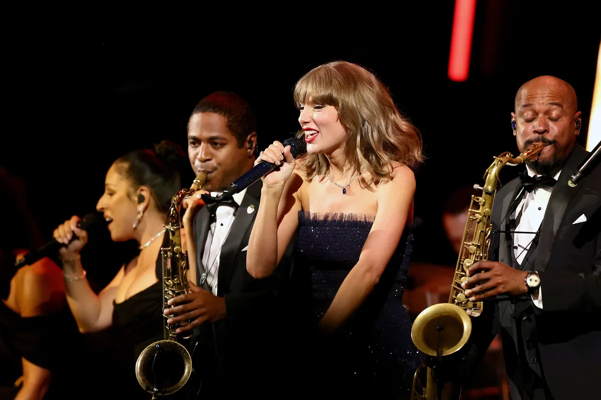Taylor Swift performing on stage at a formal event.