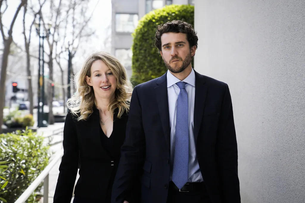 Elizabeth Holmes and Billy Evans standing together, smiling subtly.