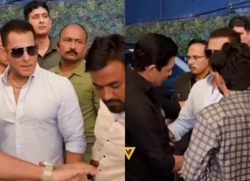 Salman Khan being held back by his security as a fan reaches for his arm.