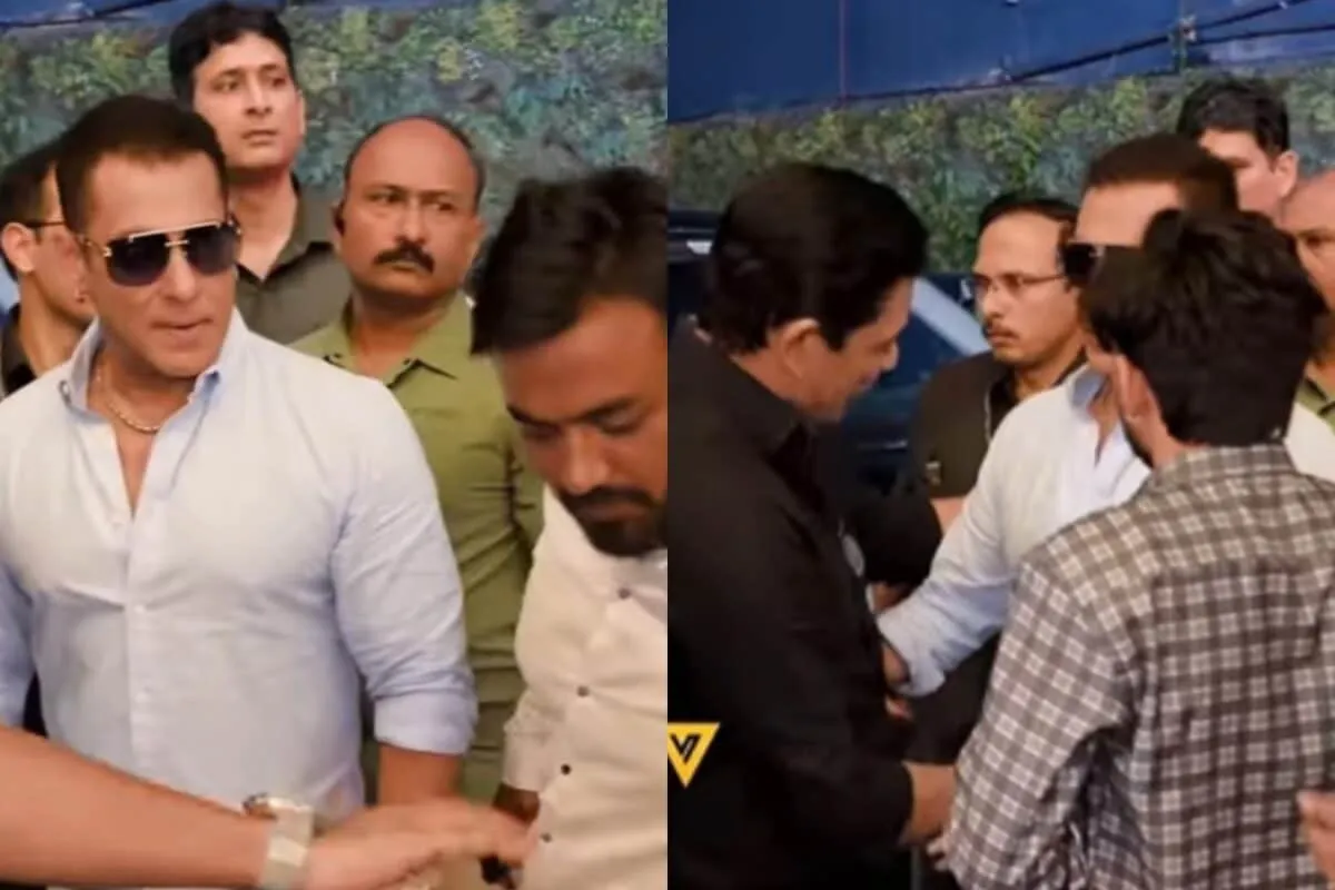 Salman Khan being held back by his security as a fan reaches for his arm.