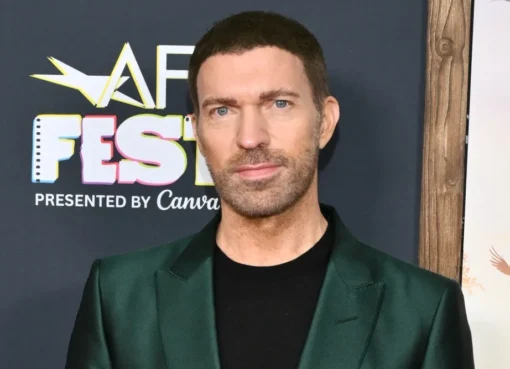 Travis Knight smiling on a red carpet.