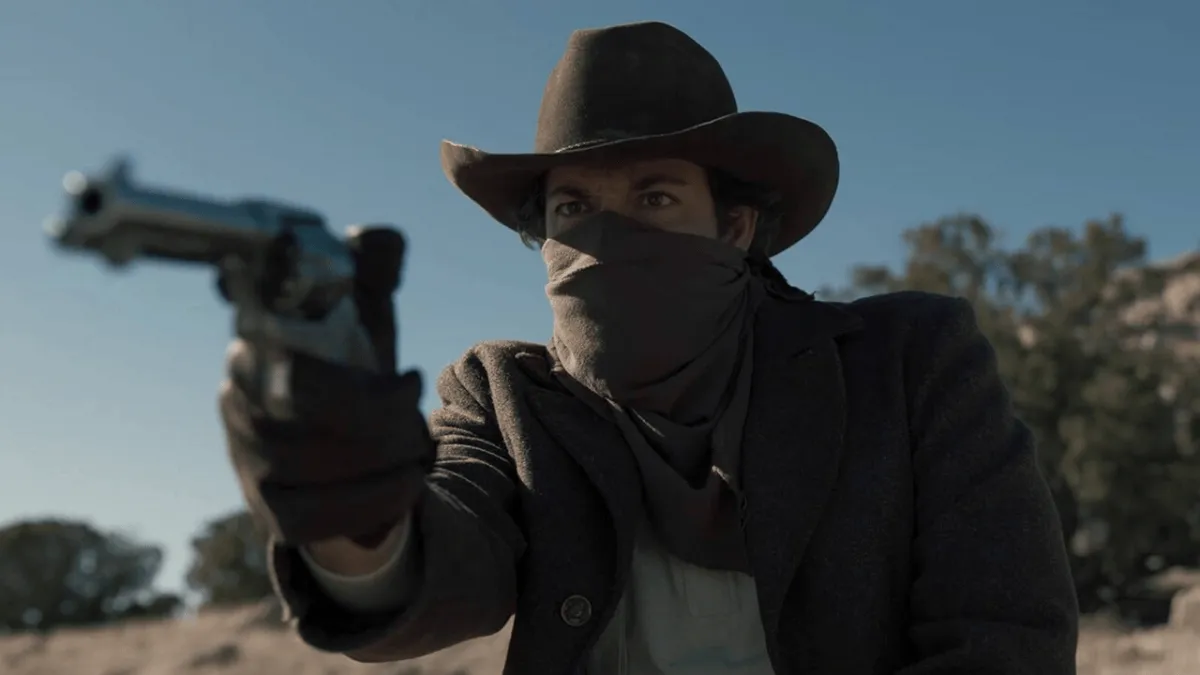 Zachary Levi dressed as a cowboy in a Western scene, looking rugged.